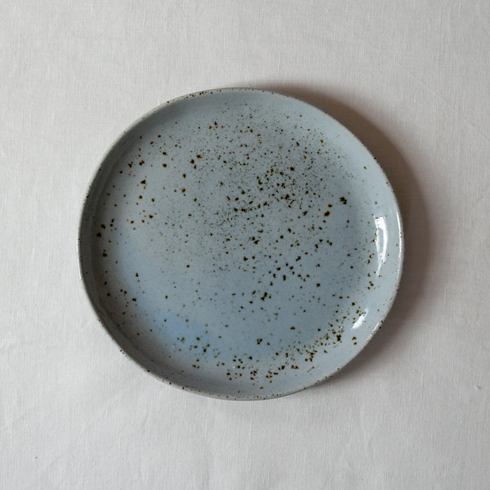 Bird's-eye view of a lunch plate by Palinopsia Ceramics on a white linen tablecloth