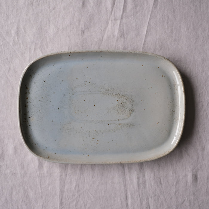 Handmade blue grey rectangle platter made from stoneware on a grey tablecloth by Palinopsia ceramics