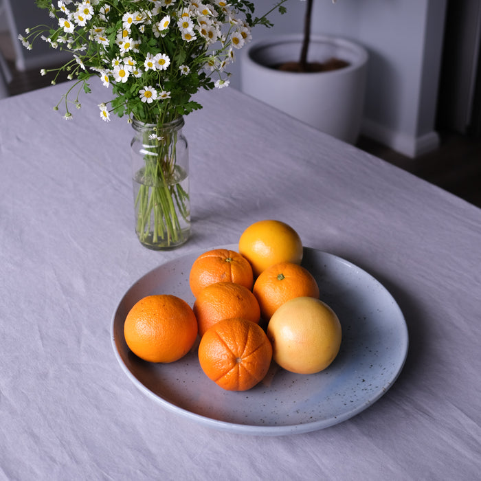 Still life image of oranges on a handmade extra large round serving platter by Palinopsia Ceramics