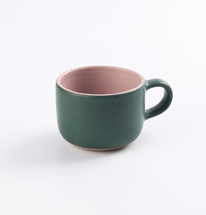 Green and pink stoneware mug by Palinopsia on a white background