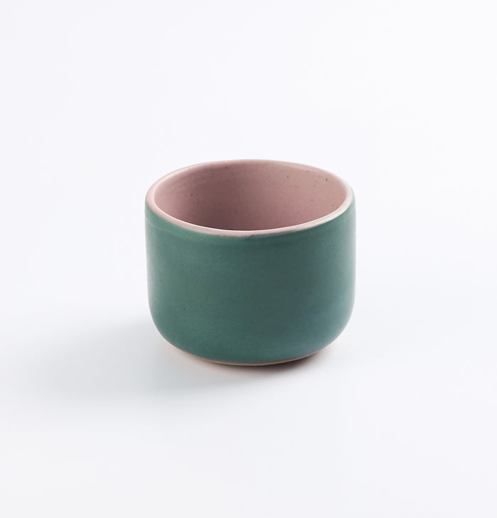 Palinopsia's green ceramic stoneware cup with pink interior on a white background