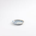 Small handmade ceramic plate with a marbled clay pattern in cobalt blue, beige and cream on a white background by Palinopsia