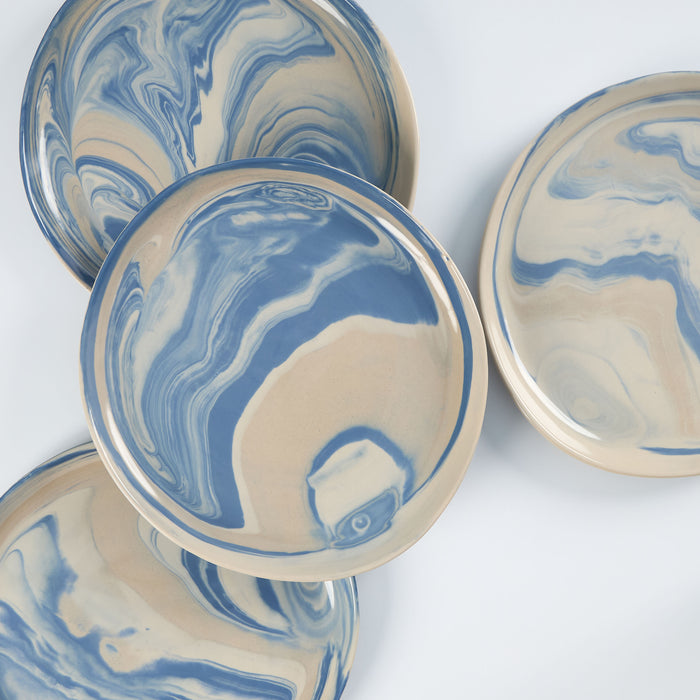 Set of four handmade ceramic plates with a marbled clay pattern in cobalt blue, beige and cream on a white background by Palinopsia