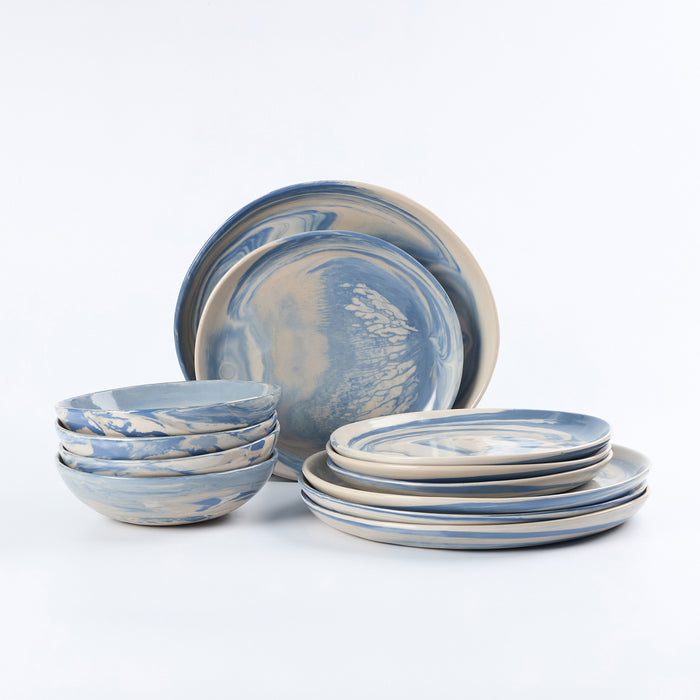 Three piece dinner set of handmade ceramics with a marbled clay pattern in cobalt blue, beige and cream on a white background by Palinopsia