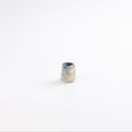 Small handmade ceramic hand pitcher with a swirling marbled clay pattern in cobalt blue, beige and cream on a white background by Palinopsia