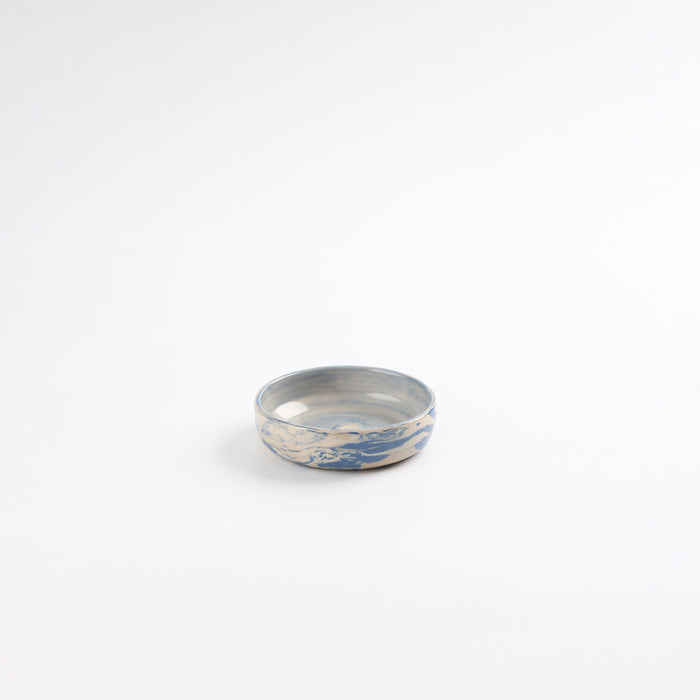 Small handmade ceramic pickle dish with a marbled clay pattern in cobalt blue, beige and cream on a white background by Palinopsia