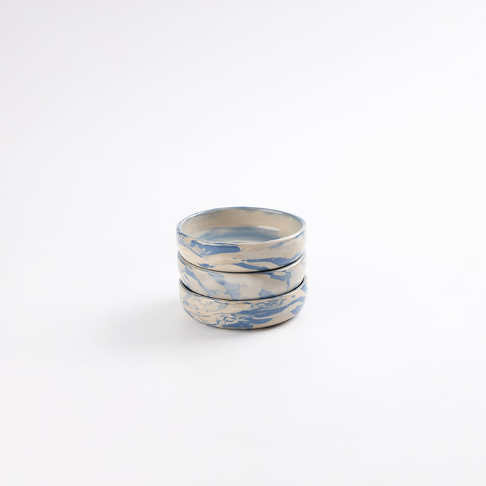 Set of three small handmade ceramic pickle dishes with a marbled clay pattern in cobalt blue, beige and cream on a white background by Palinopsia