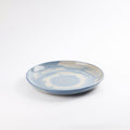 Handmade ceramic dinner plate with a swirling marbled clay pattern in cobalt blue, beige and cream on a white background by Palinopsia