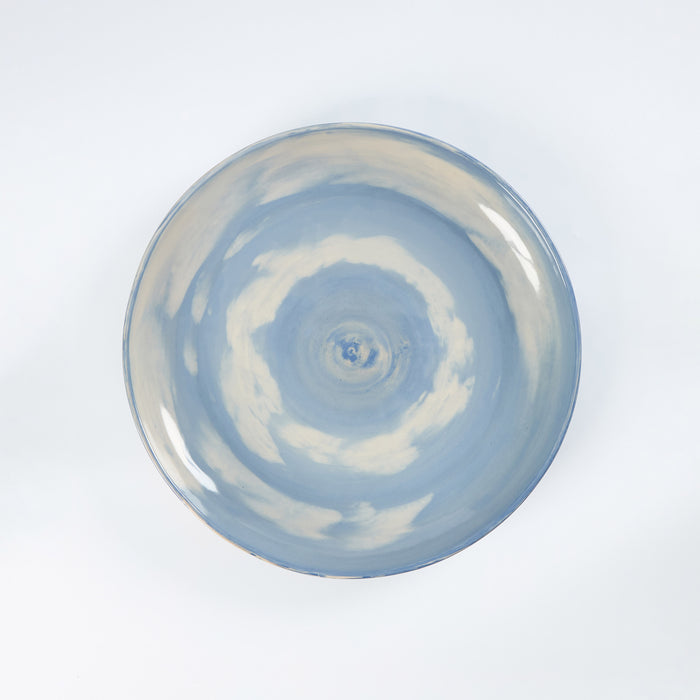 Handmade ceramic dinner plate with a swirling marbled clay pattern in cobalt blue, beige and cream on a white background by Palinopsia