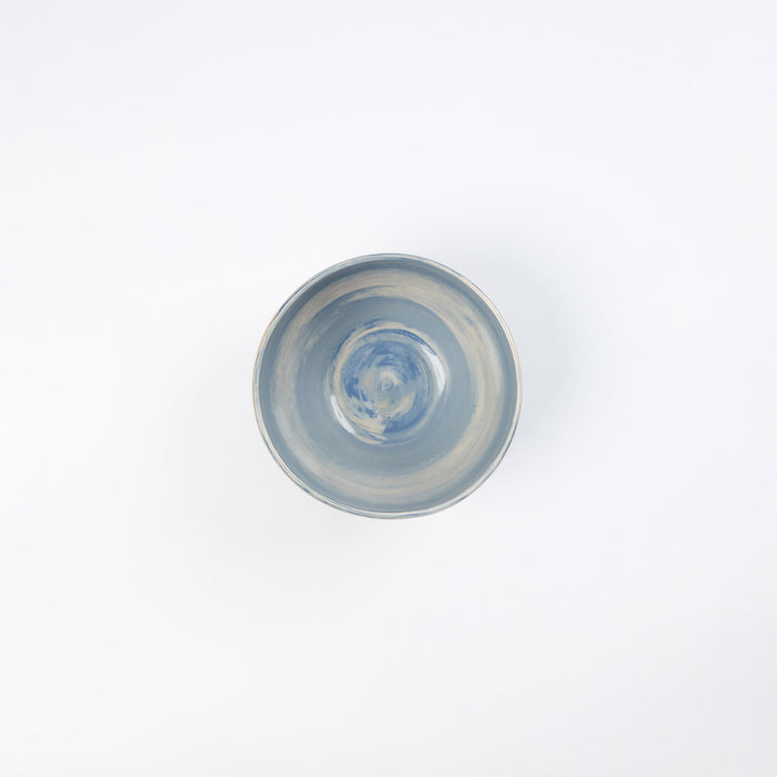 Small handmade ceramic bowl with a swirling marbled clay pattern in cobalt blue, beige and cream on a white background by Palinopsia