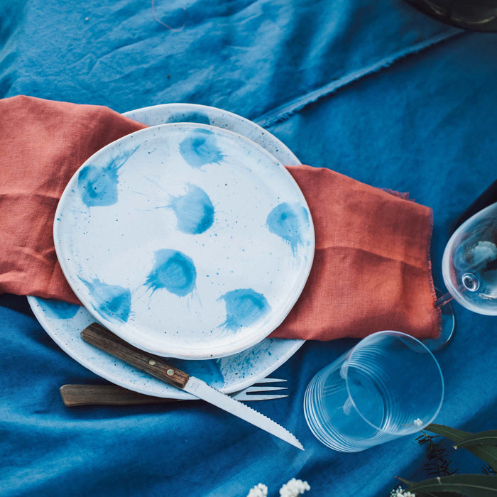 Handmade Pollock Dinner plate and lunch plate on a blue tablecloth with crystal and vintage cutlery