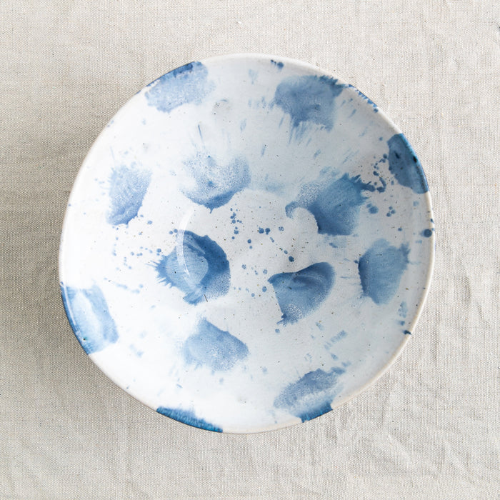 Bird's-eye view of Palinopsia Ceramics Handmade Fruit bowl with drippy melting blue and white glaze and abstract artistic design