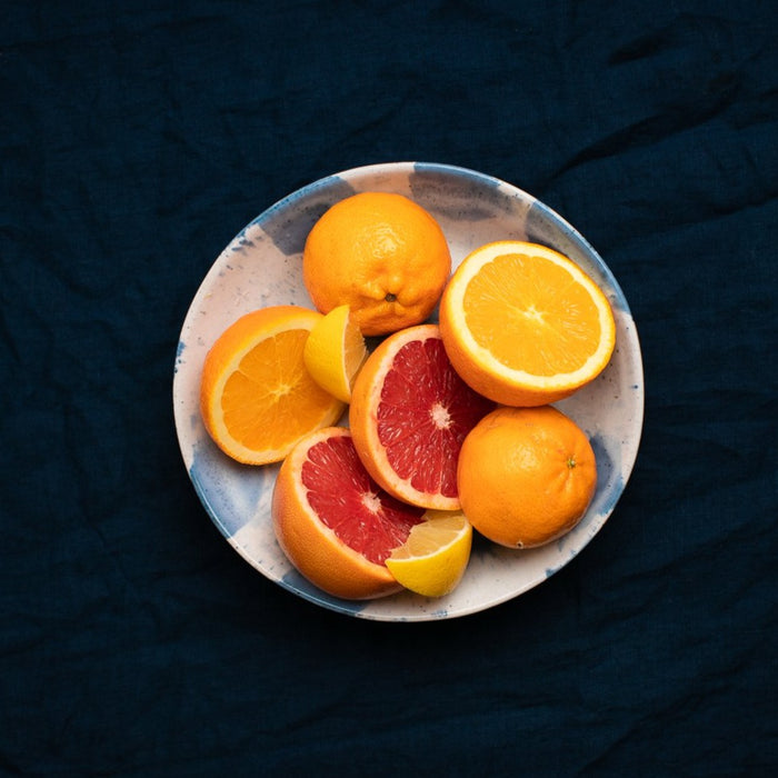 Palinopsia fruit bowl with citrus on a blue linen tablecloth