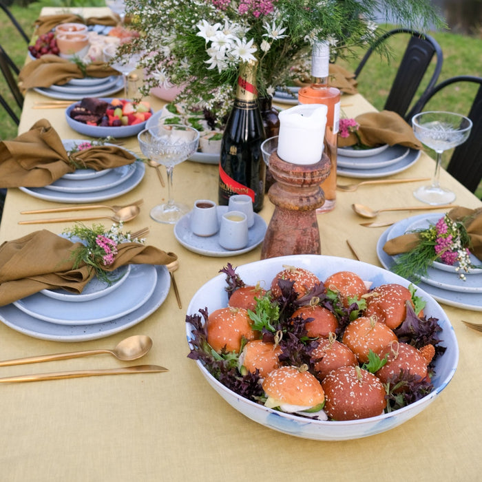 Handmade blue and white low serving platter with sliders by Palinopsia Ceramics on an outdoor dining table