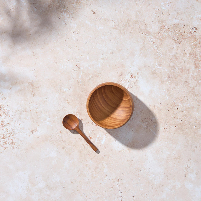 Birds-eye view of a small teak bowl with matching spoon by Palinopsia