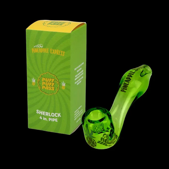 Angled close-up of the green Puff Puff Pass Sherlock Hand Pipe resting beside its matching green "Pineapple Express" box against a black background.