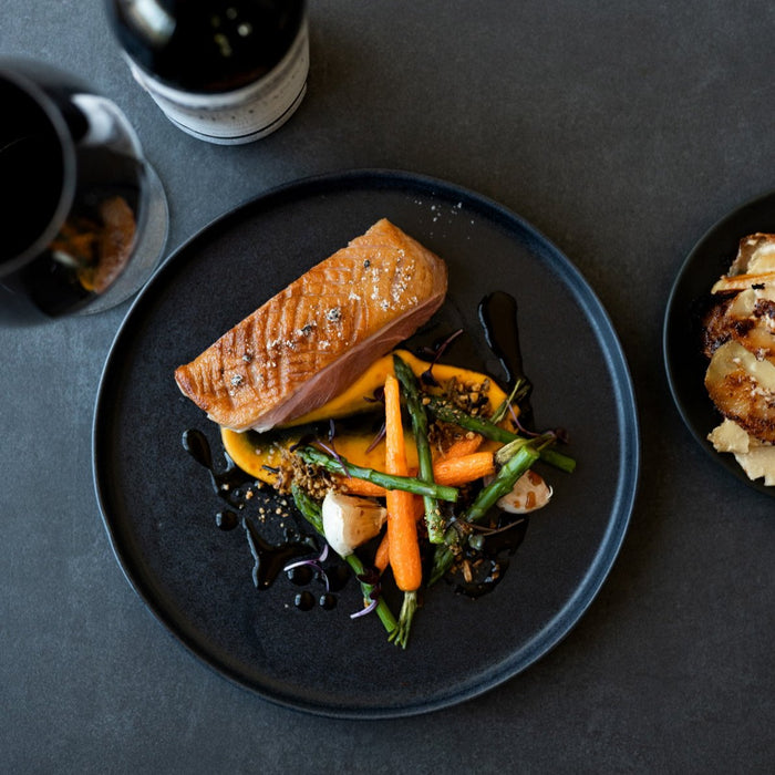 Birds-eye view of a Handmade Black dinner plate for restaurants, here a duck breast with vegetables is served by Sydney chef Gerald Touchard