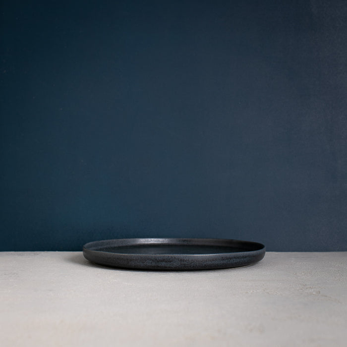 Side view of a Handmade Black dinner plate made with reactive glaze by Palinopsia Ceramics in Sydney Australia