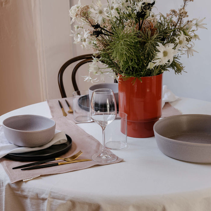 Table setting at Palinopsia's Newcastle store with white tablecloth, and handmade ceramic dinner set and low salad bowl in monochrome colours