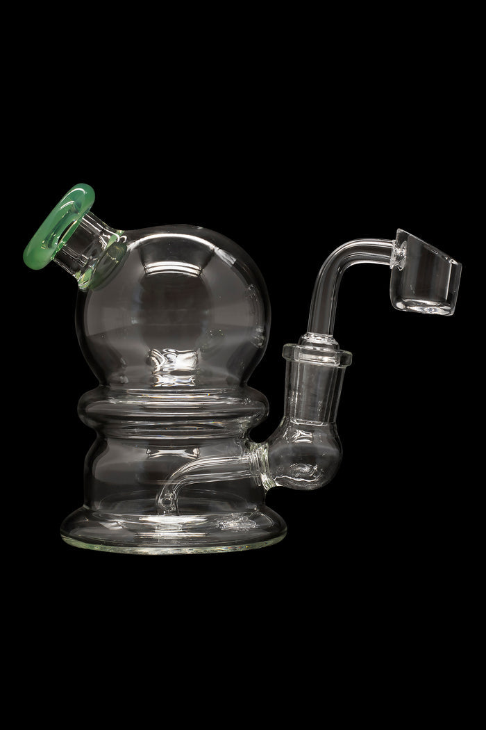 Clear glass dab rig with green accent and quartz banger.