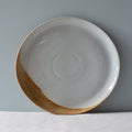 A single handmade Soda dinner plate in browns and blues