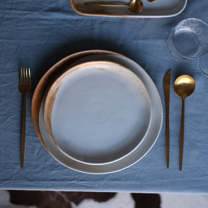 Birds eye-view of a handmade lunch plate side plate by Palinopsia Ceramics in rustic browns and blues and soda fired
