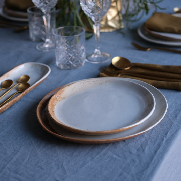 Side angle view of a lunch plate on a table setting with handmade ceramic dinner ware and dinner sets