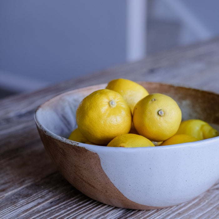 Detailed shot of a handmade ceramic rustic vintage inspired fruit bowl in browns and blue glaze