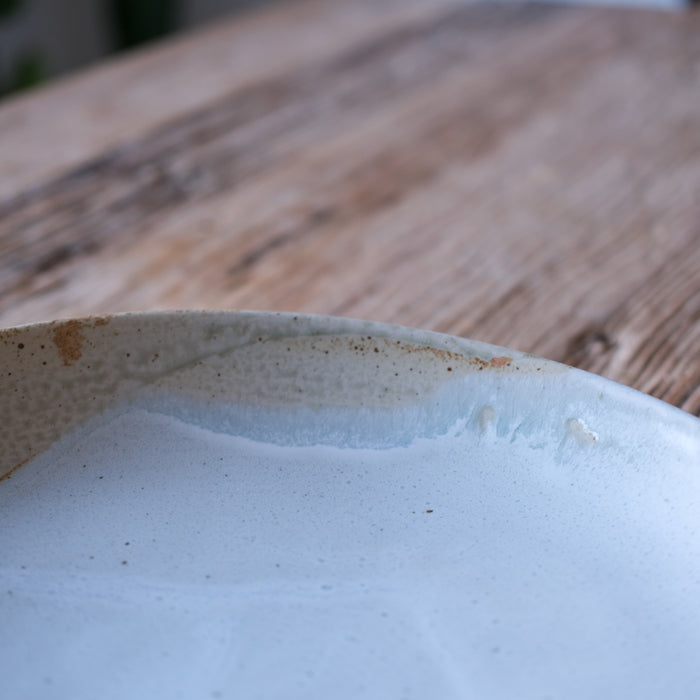 Detailed shot of a round large low serving platter in two tone brown and blue, handmade stoneware by Palinopsia ceramics