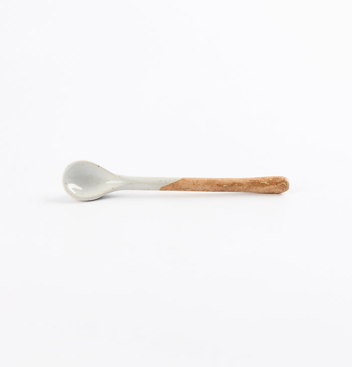 Ceramic teaspoon with two tone blue and brown colours on a white background