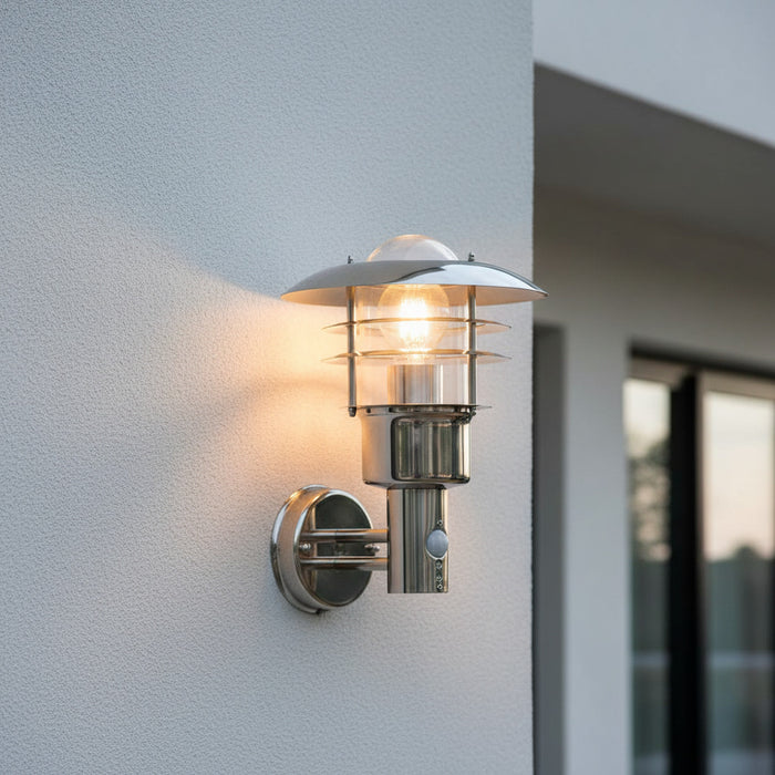 stainless steel external wall light with PIR sensor mounted on the wall outside a modern home