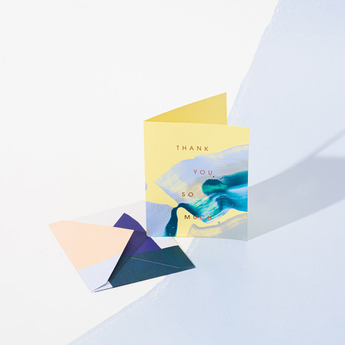 Thank You So Much handmade artisanal greeting card with blue and yellow paint swirls and an envelope on a geometric background